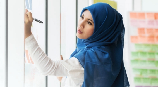 Woman with endometriosis writing on board